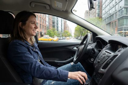 Femme détendue au volant d'une voiture urbaine moderne