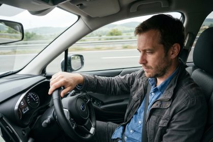 Homme en voiture sur l'autoroute v&eacute;rifiant le tachometre