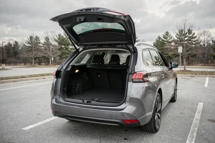 Coffre ouvert de la Peugeot 308 SW avec espace de chargement généreux en vue trois quarts arrière