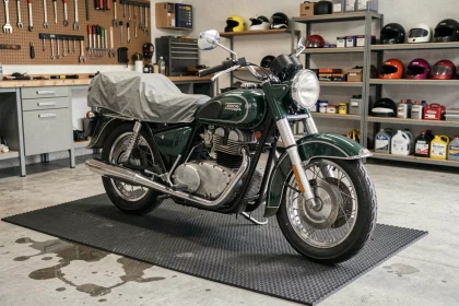 Moto vintage garée sur un tapis de garage épais en caoutchouc pour l'hivernage, demi-couverte d'une housse respirante dans un garage propre